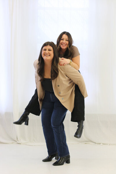 The Only Sunshine Creative Studio Co-founders on each other's backs