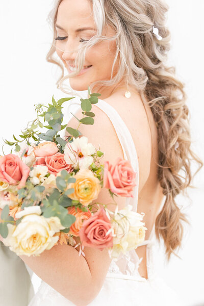 bright light and airy wedding photo of bride  with bouquet
