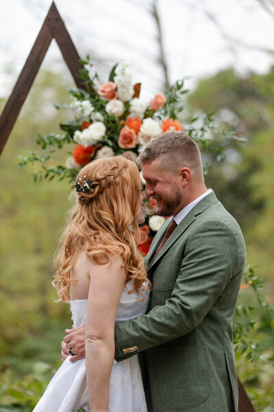 Bride and groom are facing each other, noses rubbing together