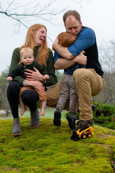 Family photo on mossy rock in Freeport, Maine