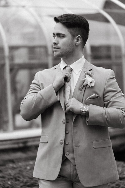 Portrait of NYC wedding and elopement photographer Dom Augustine dressed in a suit, ready to capture a couple’s big day.