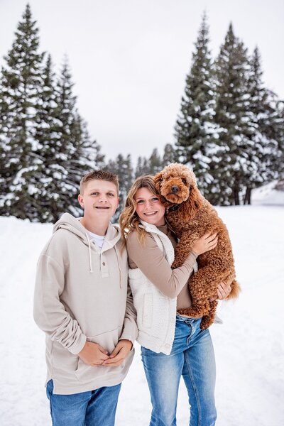 siblings with dog in snow