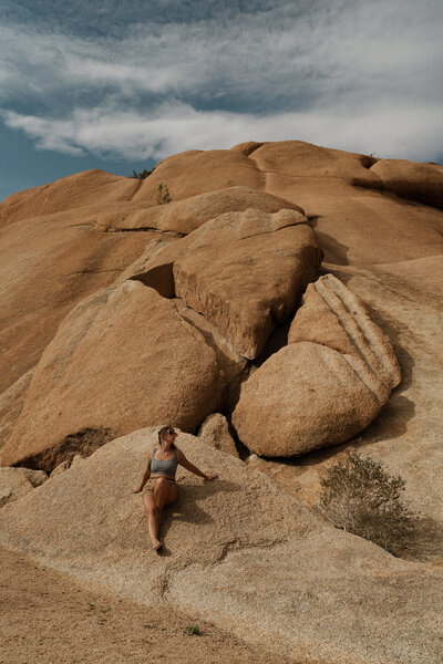 portrait of destination elopement photographer leaning against a rock in