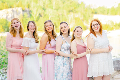 6 seniors in pastel dresses hugging at Klondike Park