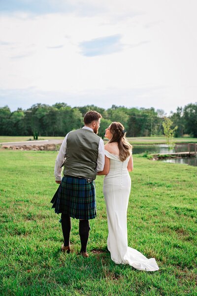 Scottish couple comes to Nashville to Elope. Walking hand in hand away from the camera beside a pond at sunset