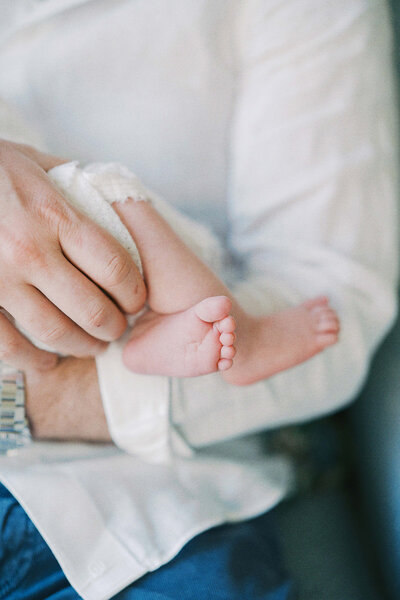 close up photo of a dad's hand and baby toes
