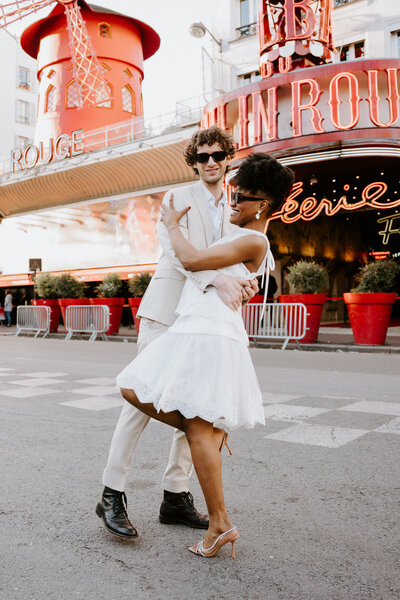 Couple dancing in Paris in front of Moulin Rouge