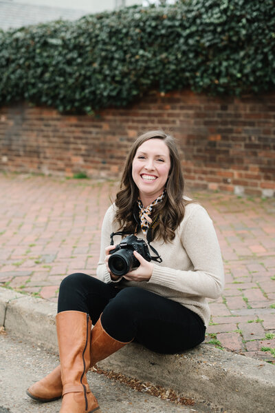 Photographer Mary Catherine holding camera and smiling - Northern Virginia family photographer