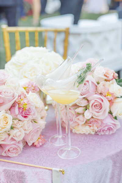 Wedding reception table with champagne glasses and pink and white flower bouquets