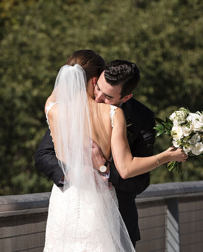 Bride and groom embrace during first look on the Nichols Bridgeway in Chicago