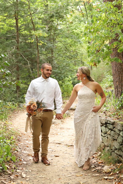 Couple walking on a path in the woods of North Carolina on their wedding day