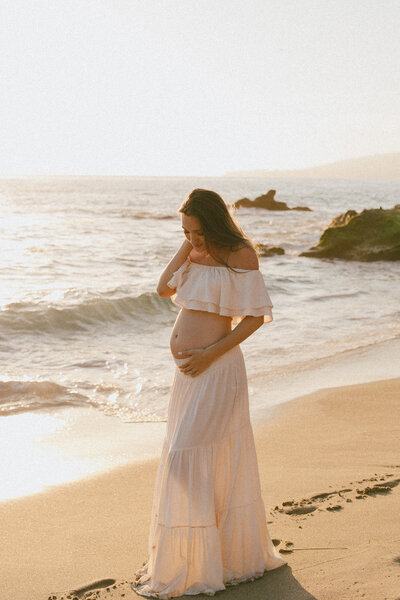 Pregnant woman on beach in Laguna Beach at sunset