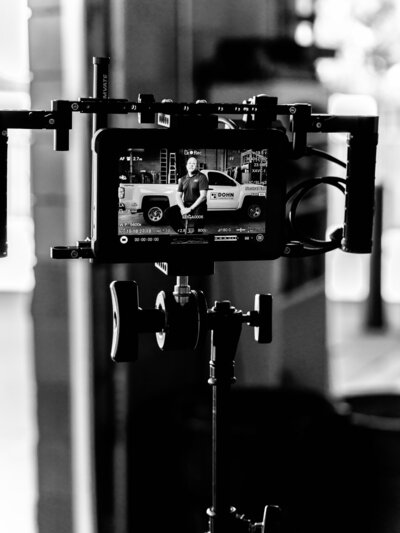 A professional videographer fine-tuning a camera on set, highlighting the commitment to quality and excellence in video content creation at Future Fox Media in Denver, Colorado.