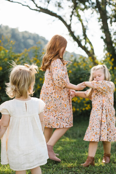 three sisters playing in an open field