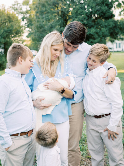 A family smiling at a baby held by the mother during a family photography session in RIchmond by Katie Stansfield Photography.