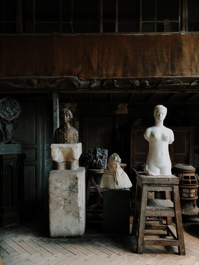 A curated collection of antique sculptures displayed within the grandeur of a historic building, where artistry and history converge.
