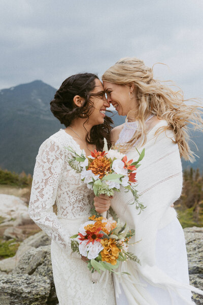 two brides smiling with their foreheads together during their elopement on Mount Washington in New Hampshire