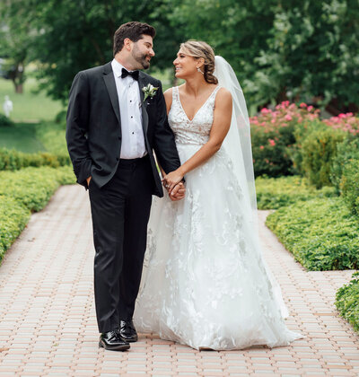 Bride and groom walking hand-in-hand during spring wedding | Ryland Inn | Whitehouse Station, New Jersey