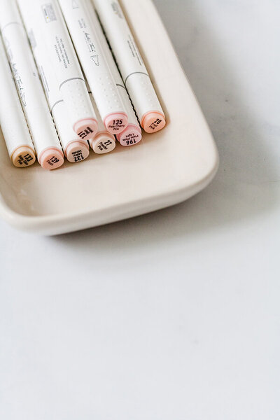Pens in shades of pink sitting on a tray