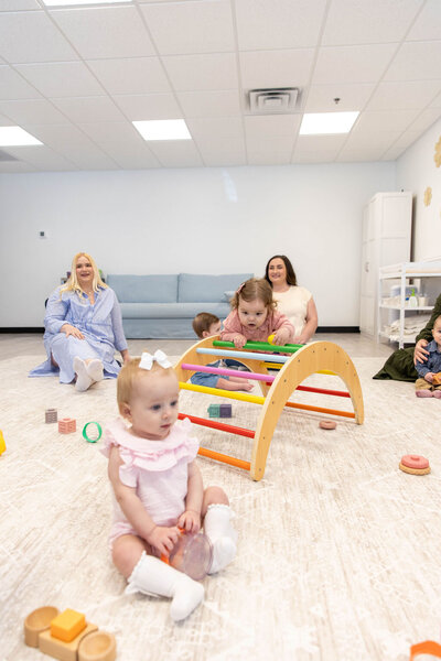 Group of babies playing with color wooden toys