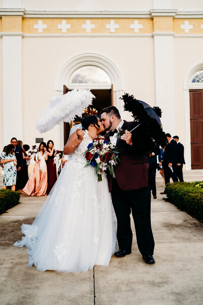bride and groom second line kissing pose after catholic wedding in st. martinville, louisiana