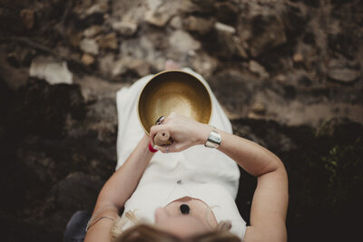 Energy healer Caroline Weiss using a singing bowl to support meditation, sound healing, and emotional balance.