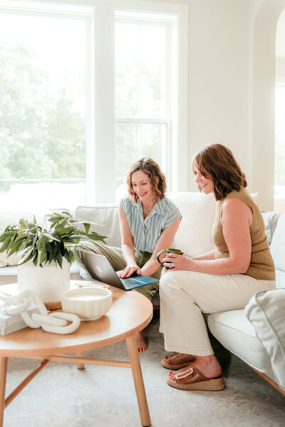 Two women collaborating during a relaxed branding photography session in a bright Minneapolis home