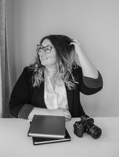 Port Huron MI wedding photographer Catie sitting at desk