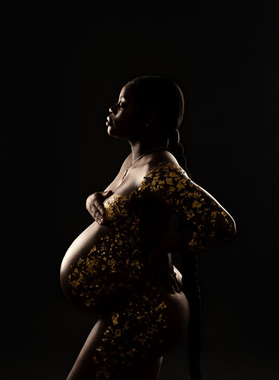 Studio maternity portrait with gold foil leaf art applied to the client's skin
Description: