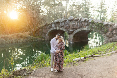 man and woman standing next to water while embracing
