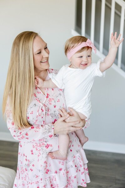photographer minneapolis Kacey Wyrick, holding her daughter who is waving