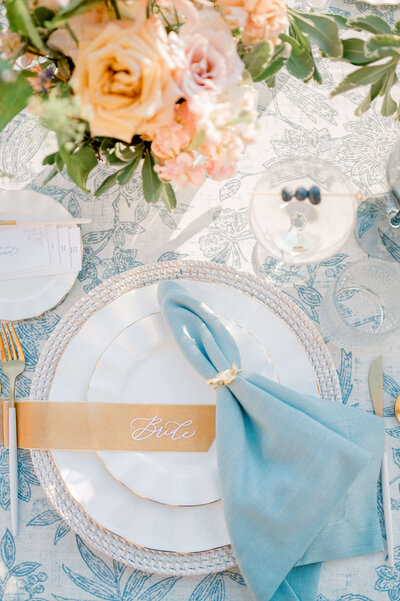 a place setting for a blue and orange themed wedding
