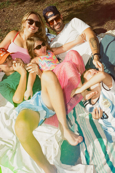 Couple holding baby in air in a park at Austin family photoshoot