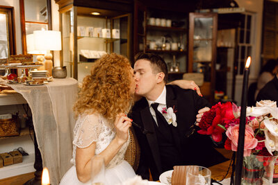 Bride and groom share a candid kiss after enjoying their wedding cake during an intimate backyard reception in Richmond, Virginia.