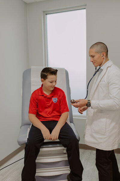 Doctor using a stethoscope on a young boy
