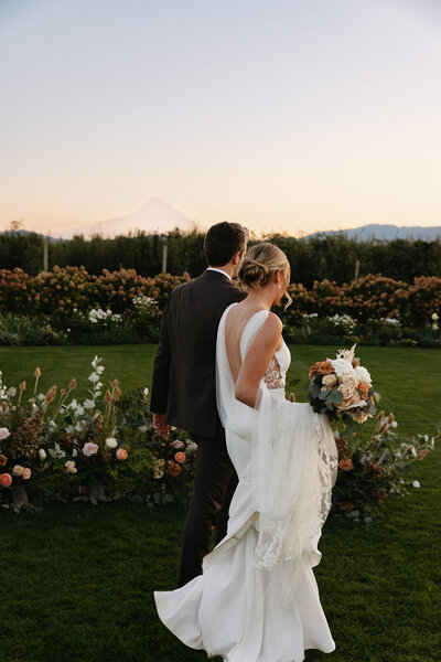 XO Social Haus Wedding Planner Oregon Destination Pacific Northwest Wedding Planners Event Planners Wedding Planning Stephanie Laur Seattle Wedding Venues Venue Couple Walking Hand in Hand at The Orchard
