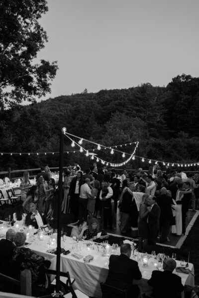 Black and white image of wedding reception under string lights