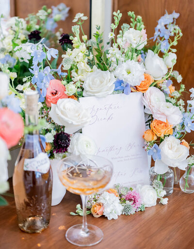 Wedding bar sign with flower arrangement.