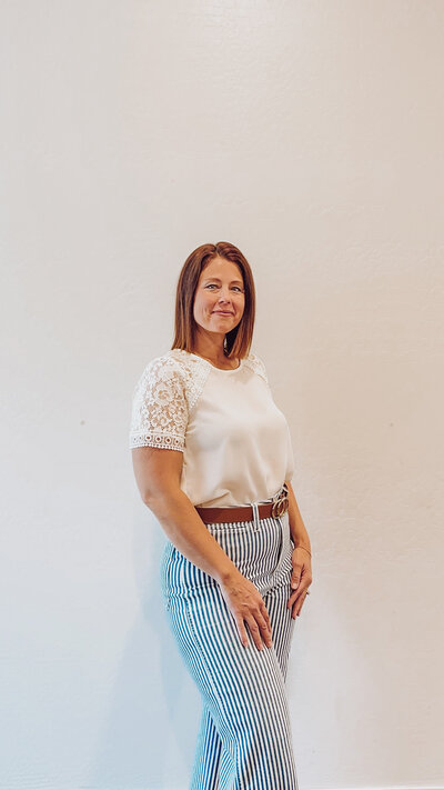 Founder Alli Standing wearing a cream top and striped pants