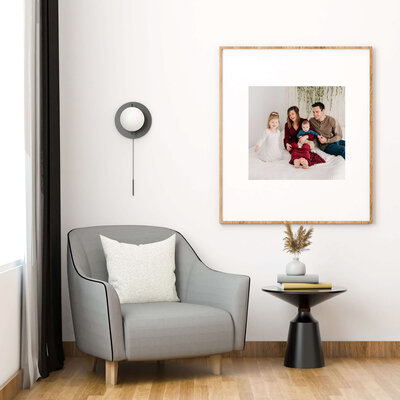 framed family newborn  picture in Branson MO of family sitting on bed in studio