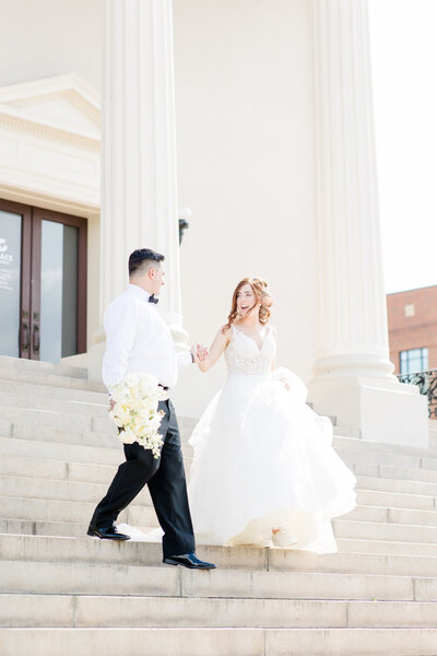 bride and groom walking on steps at their wedding venue
