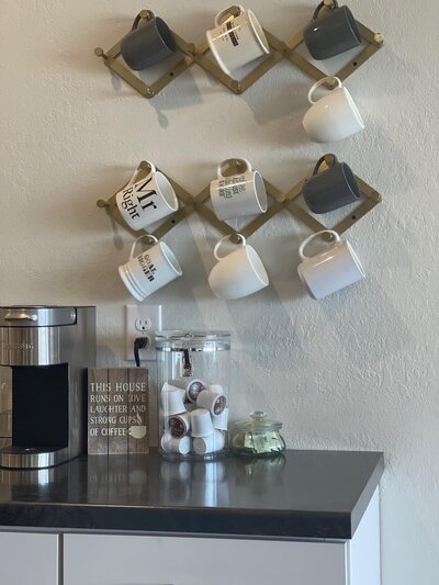 coffee station with mugs hanging on a wall