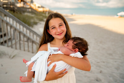 family photography of daughter holding baby brother