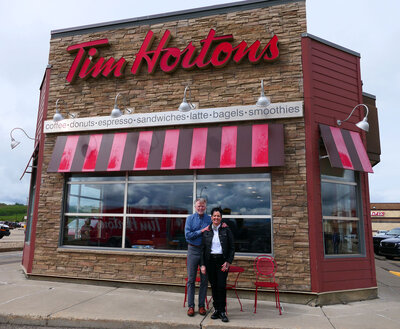 Barb and Gord standing outside one of their Tim Horton's locations in Peace River Alberta