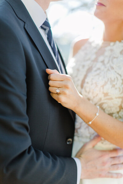 brides holding grooms suit jacket and looking at him