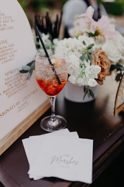 aperol spritz and custom bar napkins styled on bar at wedding