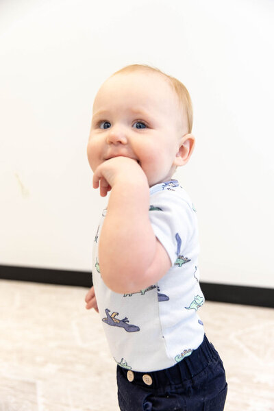 Baby playfully chewing on his hand