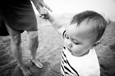 A young boy holds his mother's hand during a family photo session in Toronto Ontario.