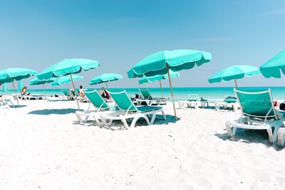 turquoise blue beach umbrellas and beach chairs lined up along white sandy beaches for user generated content socialfizz