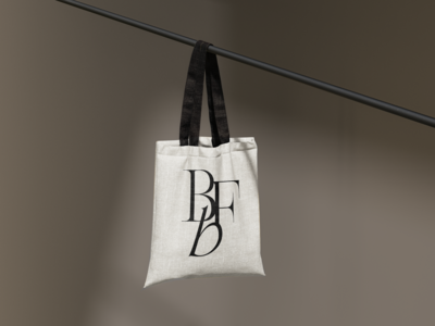 Elegant monogram logo mockup on natural canvas tote bag with neutral warm gray background in Knoxville